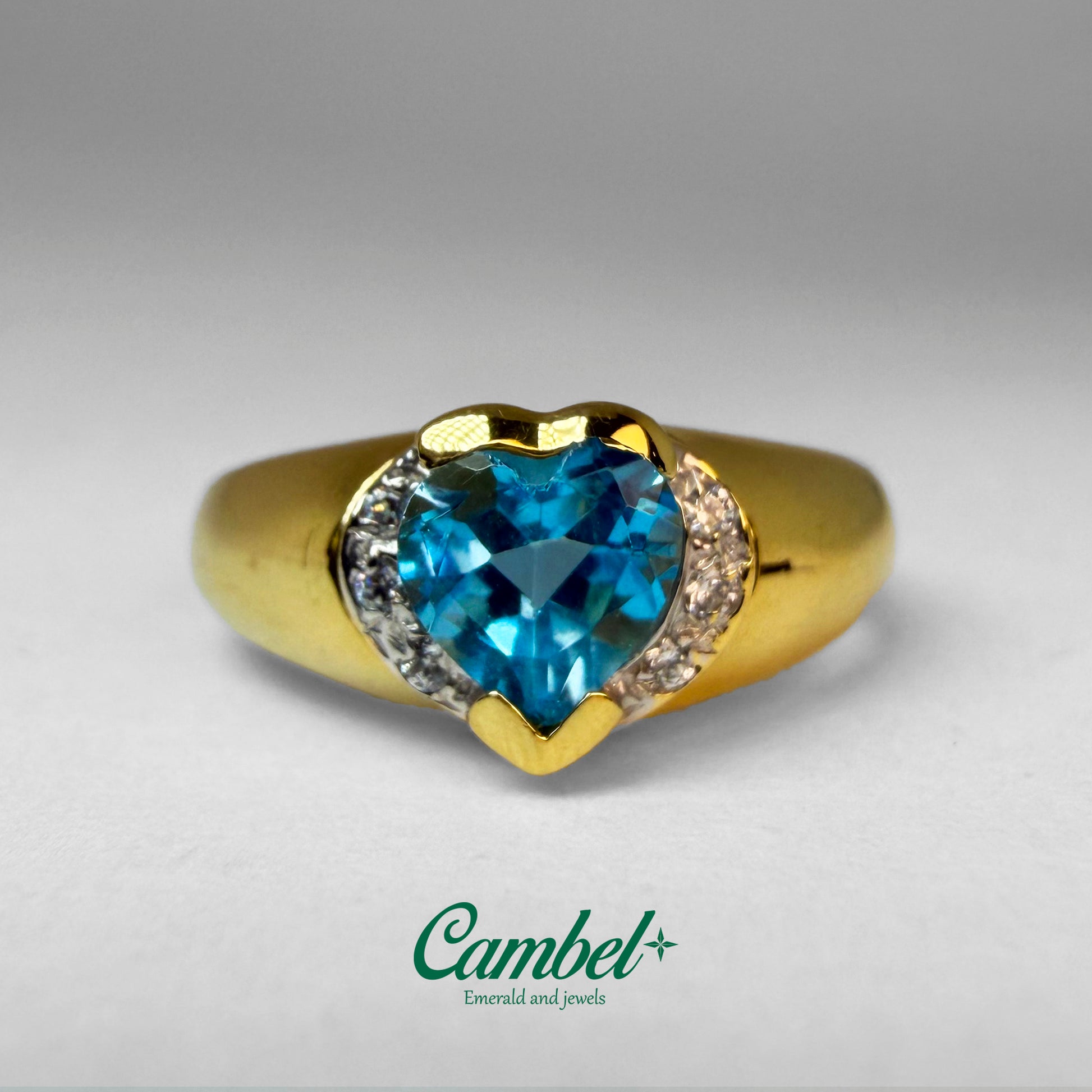 Fotografía en detalle de Anillo de diseño corazón en oro de 18k con un majestuoso topacio Swiss Blue natural y diamantes, alta joyería de Cambel