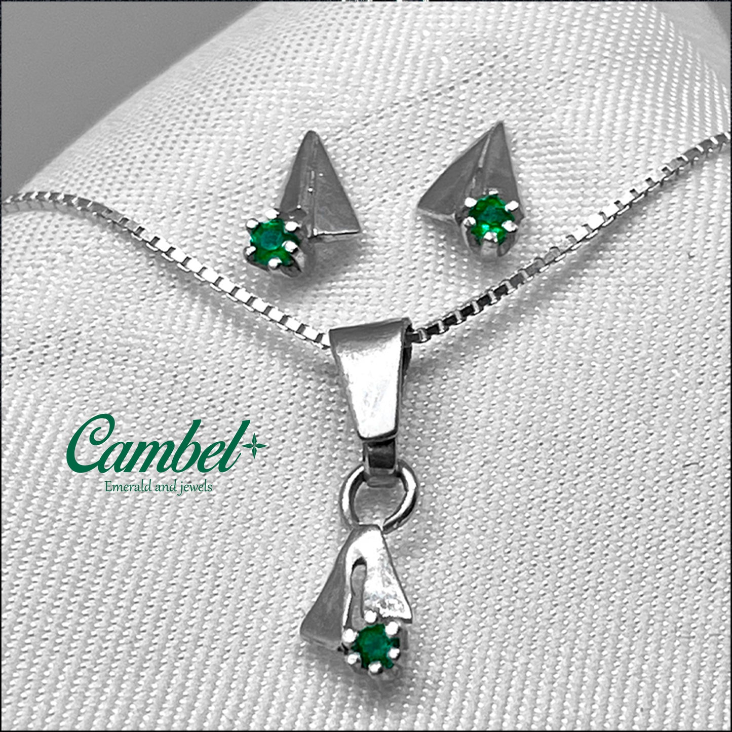 Fotografía de Set Essentials de Cambel: Dije y aretes con diseño de velero en plata esterlina 925 y tres esmeraldas colombianas naturales.